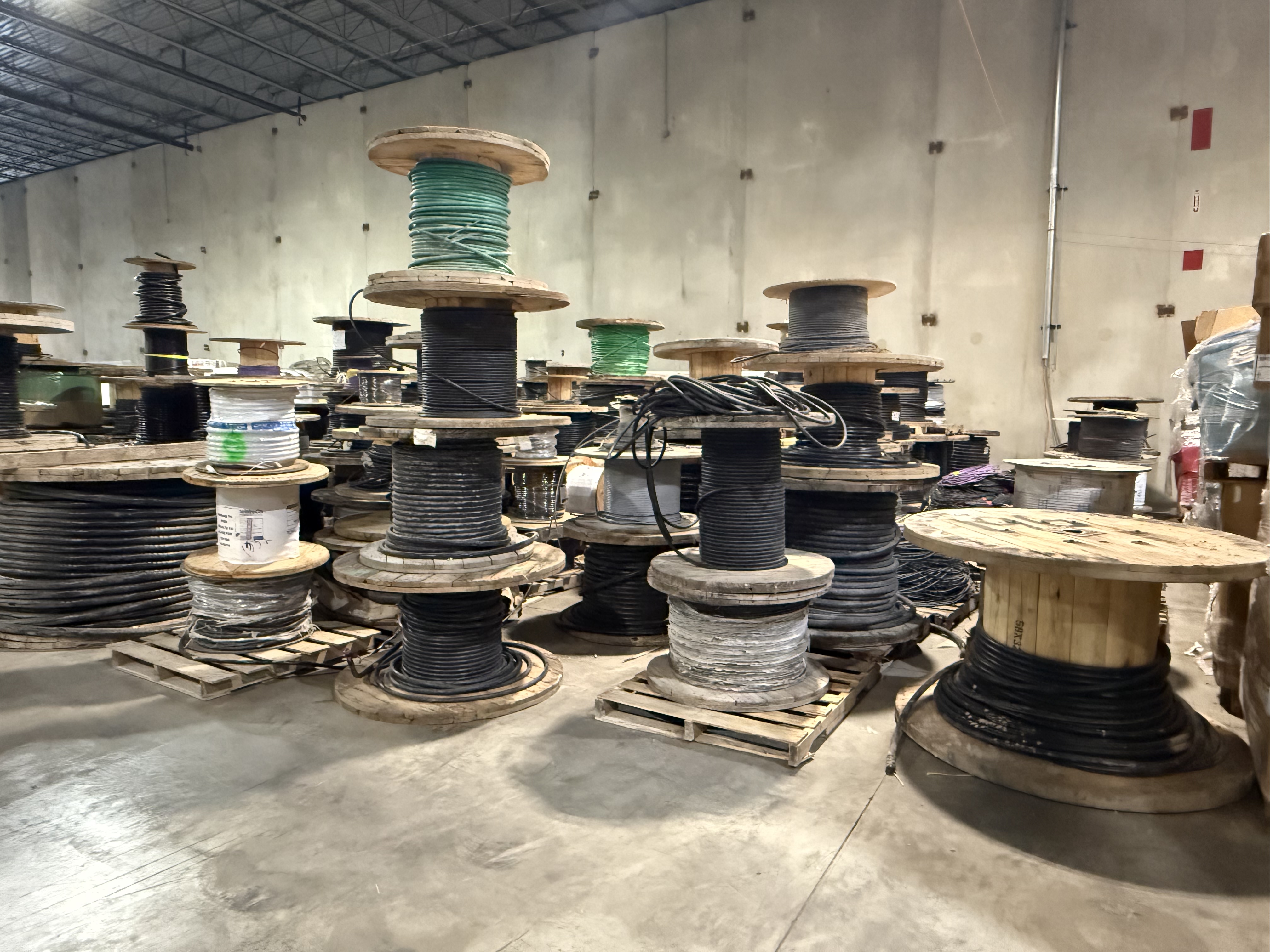 Labeled reels and packaged project-surplus electrical cable staged for inventory review
